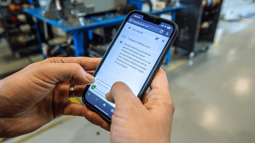 An image of a manufacturing employee using L2L Assist on a phone.