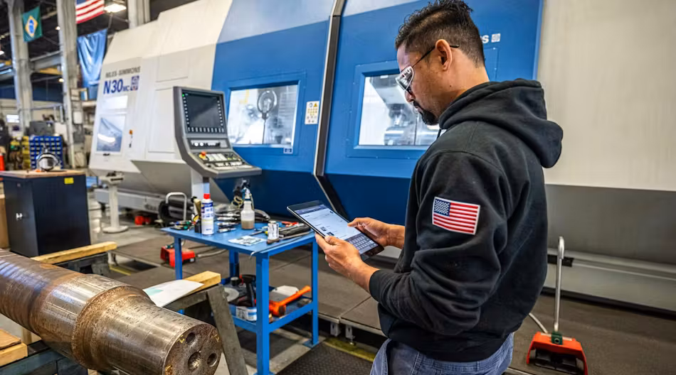 A manufacturing employee using a tablet on the shop floor.